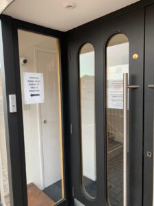 Front door notice asking visitors to press the buzzer for reception
