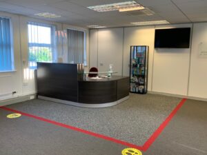 Reception desk with red social distancing lines on the floor