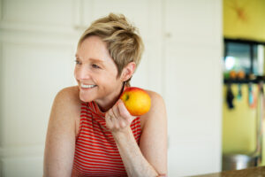 Smiling woman about to bite into an apple