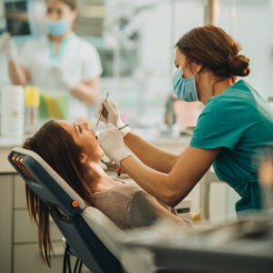 Hygienist treating a patient in the dental chair
